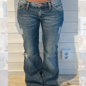 Blå bootcut jeans med slitningar - Snygga blå bootcut jeans med slitningar och lätt tvättad look. Låg midja och klassiska femficksdetaljer med coola nitar och knappar. Jeansen har en avslappnad passform och är perfekta för en trendig streetstyle. Mått 38 midja innerbenslängd 78-79❤️