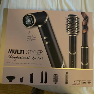 Multi Styler 6-in-1 hårstyler - Säljer en Multi Styler Professional 6-in-1 med flera utbytbara borst- och fönhuvuden. Svart och guld design, passar för att föna, locka och styla håret. Har två hastigheter, tre värmelägen och cool-funktion. Perfekt för att skapa olika frisyrer hemma. dupe på dyson och endast provad 