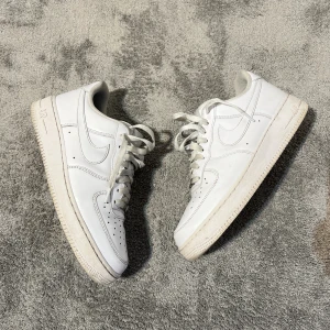 Nike Air Force 1 vita sneakers - Klassiska Nike Air Force 1 sneakers i helvitt, skick enligt bild, perfekt som slit o släng skor! Går enkelt att tvätta snören!