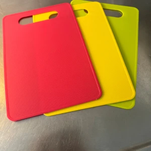 Skärbrädor i plast, - Tre färgglada skärbrädor i plast, i rött, gult och grönt. Perfekt för köket, lätta att rengöra och med praktiskt handtag. Alla ser ut att vara i mycket gott skick utan synligt slitage eller repor. Säljs som set.