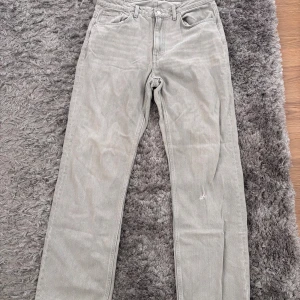 Grå raka jeans i klassisk modell - Snygga grå jeans med rak passform och hög midja! En liten  detalj är att det tyvärr finns en ett litet hål på ena benet