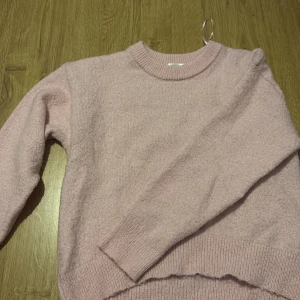 Ljusrosa stickad tröja Gina Tricot - Supermjuk ljusrosa stickad tröja från Gina Tricot. Tröjan har rund halsringning, ribbade muddar och är långärmad. Perfekt för dig som gillar en enkel och mysig stil.