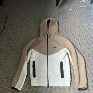Nike tech tröja - Tjena säljer en vit och beige Nike tech tröja, den är väldigt fin i skicket och använd fåtalgånger. Det är storlek M. Bara att höra av sig vid frågor! Pris går att diskutera!🤝