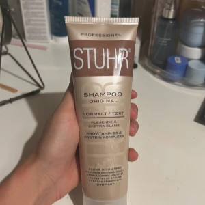 STUHR Shampoo Original - STUHR Shampoo Original för normalt/torrt hår, 200 ml. Innehåller provitamin B5 och proteinkomplex för extra glans och vård. Professionell kvalitet från Danmark. Förpackningen ser ut att vara i mycket gott skick utan synligt slitage.