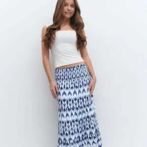 Blåvit långkjol med mönster - Supersnygg långkjol i blått och vitt med ett unikt mönster och smock i midjan. Kjolen har en avslappnad passform och är perfekt för varma dagar. Lätt och luftig känsla som ger en chill vibe till din outfit.