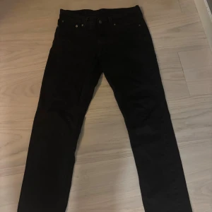 Svarta Levi's 511 jeans  - Svarta Levi's 511 jeans med klassisk femficksdesign och rakt snitt. Jeansen har en smal passform och är tillverkade i mjukt denimtyg. Snygga detaljer som Levi's röda etikett på bakfickan och svart läderpatch i midjan.