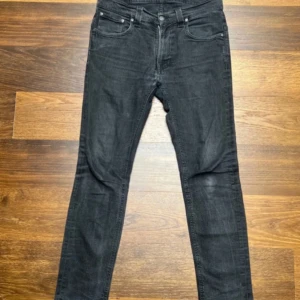 Svarta skinny jeans från Nudie Jeans - Säljer dessa fina Nudie Jeans i storlek 33/34! Längd 105 cm, bredd 40 cm. De har en defekt mellan benen som man ser på sista bilden. Priset är inte hugget i sten. Hör av dig vid frågor! Fraktar oftast samma dag😁