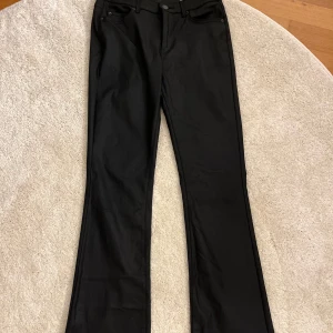 Svarta bootcut jeans från Vero Moda - Svarta jeans från Vero Moda med bootcut passform och klassisk femficksdesign. Jeansen är i stretchigt denimtyg och har normal midja. Perfekta för dig som gillar en stilren och tidlös look.