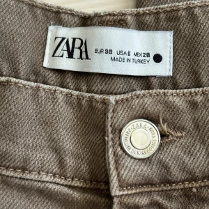 Beige wide jeans från Zara - Säljer ett par snygga jeans från Zara i höstens färg, storlek 36. Modellen är högmidjad med raka, vida ben och klassiska fickor. Materialet är kraftig bomull med jeansstruktur.