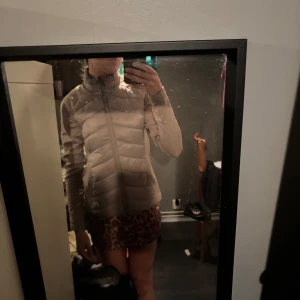 Beige lättviktsjacka XS  - Säljer en beige lättviktsjacka i storlek XS. Jackan har en smal passform, hög krage och dragkedja framtill. jackan är lätt varderad men inte på armarna. Enkel och stilren design som funkar till det mesta.