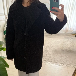 Svart teddyjacka  - Mysig svart teddyjacka med stora slag och knäppning framtill. Jackan har en rak passform och är tillverkad i ett fluffigt teddy-material som håller dig varm. Använd fåtal gånger. Inga fläckar kommer från ett djurfritt hem 