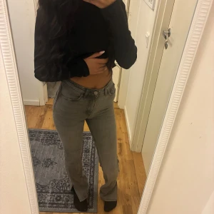 Grå bootcut jeans med hög midja - Säljer ett par gråa jeans med bootcut-modell och hög midja. Jeansen har klassisk femficksdesign och raka ben som släpper ut lite nertill. Snygg, enkel tvätt och passar perfekt till crop tops eller stickade tröjor. Materialet är jeans och färgen är en snygg ljusgrå ton.
