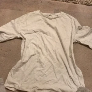 Vit t-shirt med graffiti-tryck - Vit t-shirt med coolt graffiti-inspirerat tryck på ryggen. Texten 'Find Your Way' i rosa, tecknad björn, sol och färgglada detaljer i gult, lila och svart. Skön passform och rund hals. Perfekt för dig som gillar streetstyle och unika prints.