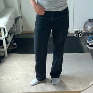 Svarta raka jeans med normal passform - Svarta jeans med rak passform och klassisk femficksdesign. Byxorna har normal midja och är tillverkade i ett robust jeanstyg som ger en stilren och avslappnad look. Perfekta för dig som gillar en enkel och tidlös stil.