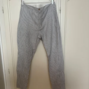 Randiga byxor från HOPE Stockholm - Snygga byxor från HOPE Stockholm i vitt och blått med smala vertikala ränder. Helt nya!
