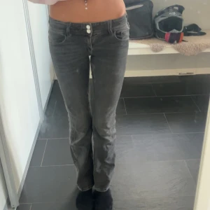 Grå jeans från Gina Tricot, stl 152 - Snygga grå jeans från Gina Tricot i storlek 152. Modellen är boot cut och två knappar framtill. Klassisk femficksdesign och normal passform. Perfekta till en chill vardagslook.