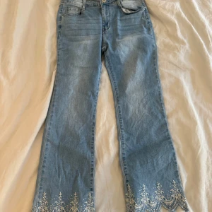 Ljusblå unika jeans  - Snygga ljusblå jeans från Newplay med unika broderade spetsdetaljer i vitt längst ner på benen. Jeansen har rak passform men är lite utsvängda.  Perfekta för dig som vill ha fina jeans med coola detaljer! De är i storlek 40 men passar 36/38- läs min bio för  information 💌