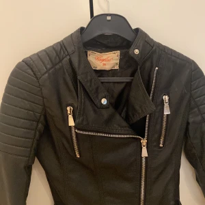 Svart skinnjacka - Snygg svart skinnjacka storlek 38, men passar någon som har S (tajt modell). Bra skick, små defekter (se bilder) men inget som direkt märks vid användning!