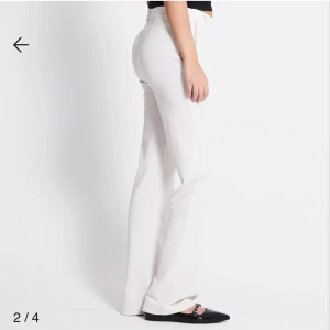 Vita wide kostymbyxor midwaist - Snygga vita kostymbyxor midwaist och wide fit. Byxorna har klassiska fickor, bälteshällor och rak siluett som ger en clean look. Materialet är slätt och känns lyxigt, perfekt för dig som gillar stilrena vibes. Passar dig som vill ha en modern och fräsch outfit.