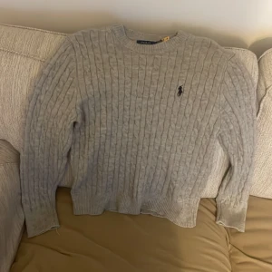 Ljusgrå stickad tröja Polo Ralph Lauren - Säljer en ljusgrå stickad tröja från Polo Ralph Lauren, oanvänd och säljer den för att den är för liten. Pris kan diskuteras 