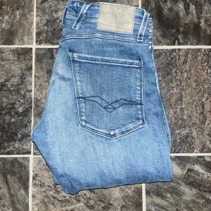 Replay Anbass jeans  - Snygga Replay Anbass jeans i ljusblå tvätt med klassisk femficksdesign och raka bakfickor med broderad detalj. Slim fit. Längd 99cm, midja 38,5cm. Ifall det inte finns någon bild i annonsen där jag bär plagget så är det för att jag ej kan ha storleken heller passformen, så kolla måtten för storlek och googla på modellnamnet för passform 😉35