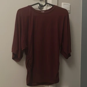 Vinröd lös topp med vida ärmar - En vinröd topp som är lite tajtare i midjan och lite längre ärmar, supermysigt material, det står att tröjan är storlek xs men jag skulle nog ändå säga att den är mer s/m i storleken❤️säljer eftersom att jag inte gillar den, tröjan är även köpt på ullared så därför lägger jag ut den för billigare pris (originalpris: 150 ungefär)