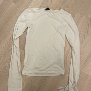 Vit långärmad tröja Gina Tricot XS - En enkel och stilren vit långärmad tröja från Gina Tricot i storlek XS. Tröjan har rund hals och är gjord i mjuk bomull, slits vid ärmarna. 