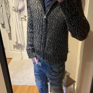 Svart och vit fodrad hoodie med dragkedja - Mysig stickad hoodie i svart och vitt. Insidan är fodrad med mjuk fleece för extra värme. Tröjan har långa ärmar och en huva. Står inte storlek men sitter perfekt på mig som är 181cm 72kg! Perfekt nu inför vinter, pris kan diskuteras! 