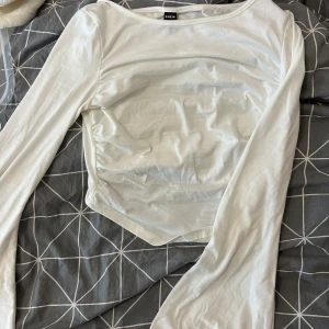 Vit långärmad topp från SHEIN - Säljer en vit långärmad topp från SHEIN i storlek XS. Toppen har en enkel och clean design med rund hals och lätt figurnära passform. Materialet känns mjukt och stretchigt, armarna är utsvängda. Aldrig använd.