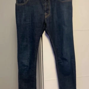 Jacob Cohen mörkblå jeans - Snygga mörkblå jeans från Jacob Cohen med klassisk femficksdesign och kontrastfärgade sömmar. Jeansen har en rak passform och patch i brunt pälsmaterial bak i midjan. Perfekt för dig som gillar exklusiva detaljer och stilren look.
