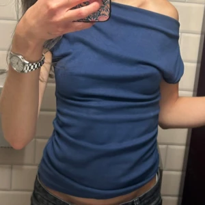 Blå topp - Blå topp med "ruff" detaljer på sidorna och lätt asymmetriska armar💙 skönt material