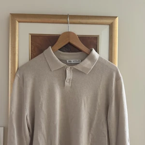 Beige pikétröja  - Snygg beige pikétröja i storlek 164. Klassisk krage med två knappar framtill och lång ärm. Perfekt basic-plagg med stilren look, passar till allt. Mjuk och skön bomullskänsla.