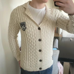 Vit Stickad cardigan - Riktigt fet vit stickad bondelid cardigan med otroligt fint mönster. Perfekt nu till kallare väder. Modellen är 180cm, 73kg. Priset kan diskuteras!