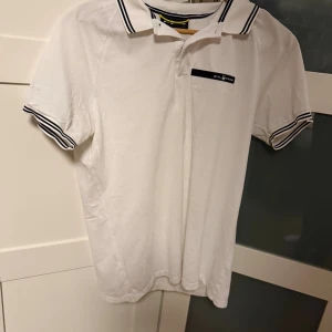 Vit Sail Racing piké med svarta detaljer - En piké som inte är använd så mycket storlek m på piké har blivit för liten för mig men den är bekväm