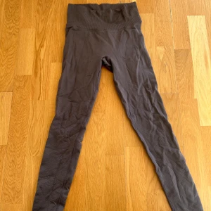 Mörkgrå seamless leggings - Säljer ett par mörkgrå seamless leggings med hög midja och ribbad linning. De är i från AIM’N 