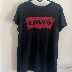 Svart Levi's t-shirt med röd logga - Svart t-shirt från Levi's som är väll använd. 