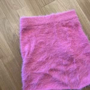 Rosa fluffig kjol från Gina Tricot - Supermjuk och fluffig rosa kjol från Gina Tricot i kort modell. Kjolen har en cool, lurvig yta som verkligen sticker ut och är perfekt för dig som vill ha något unikt. Elastisk midja för extra komfort och snygg passform. samt med en match under topp till 