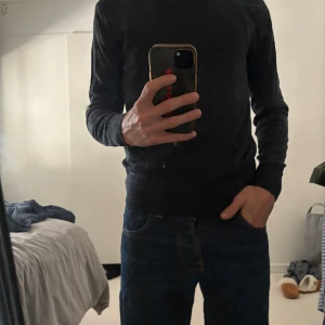 Mörkgrå merinoull tröja från Uniqlo - En stilren mörkgrå merinoull tröja från Uniqlo’s storlek S  med rund halsringning och långa ärmar. Perfekt för lager-på-lager och funkar lika bra till ett par blå replay jeans du kan hitta på våran plick😉! Den mörka färgen passar perfekt nu till hösten och vintern. Matrialet är lite tunnare och ger mer luft. Tveka inte på att skriva till oss!