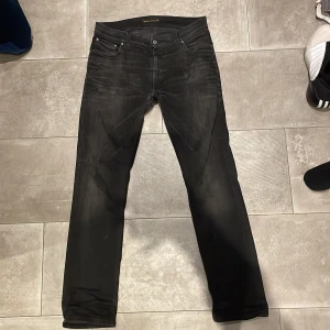 Svarta jeans från Nudie Jeans - Svarta jeans från Nudie Jeans modell thin finn i storlek 34 32 sitter normalt snygga slitningar och tvättning.