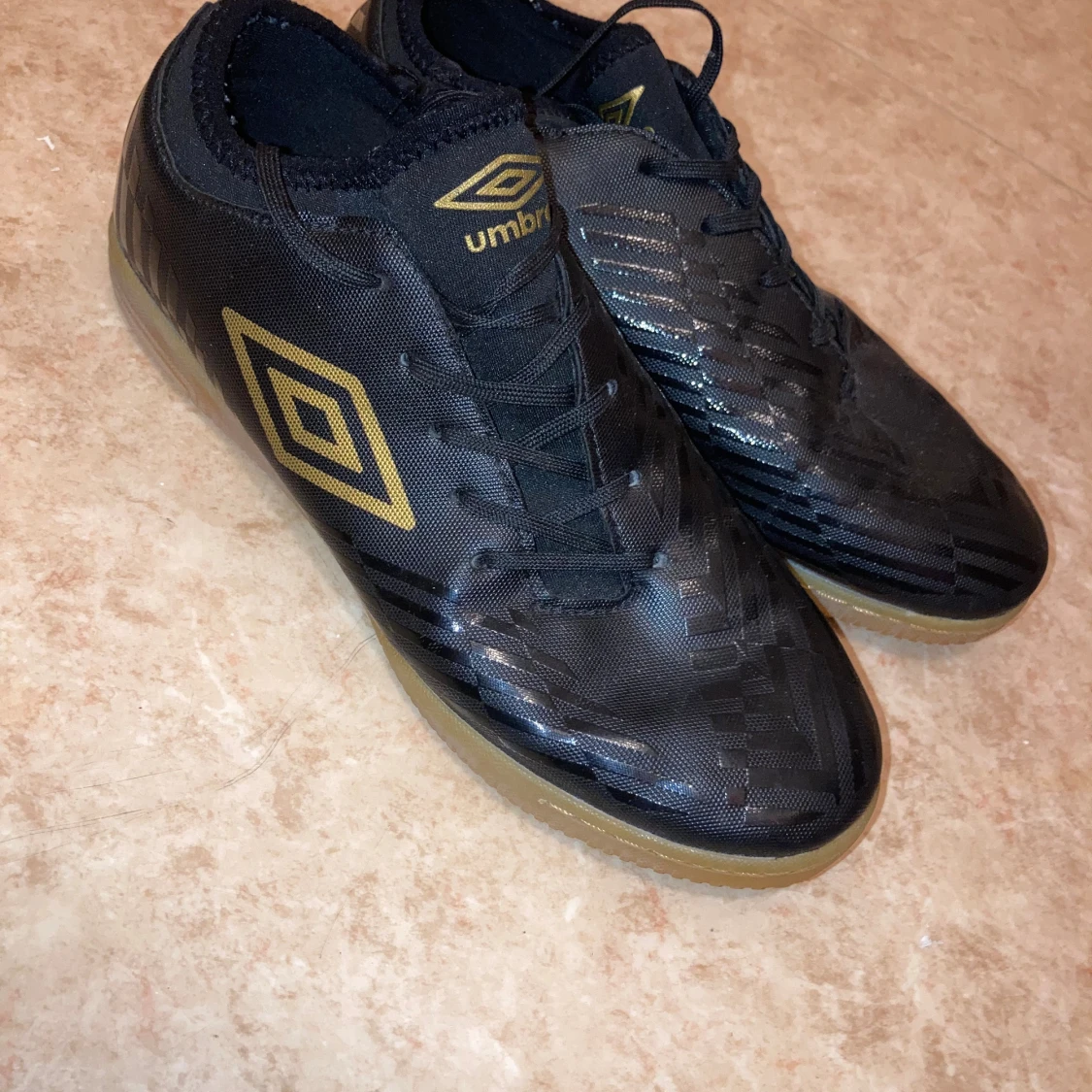 Svarta Umbro inomhus fotbollsskor med guldlogga