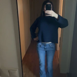 Blå bootcut jeans från 157 - Säljer ett par klassiska blå jeans från 157 med bootcut-modell och låg midja. Jeansen har en snygg tvätt, fem fickor och orangea sömmar. Perfekta för dig som gillar en avslappnad men ändå trendig look.