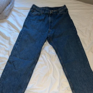 Levi's 501 blå jeans straight fit - Klassiska blå HM jeans med rak passform och fem fickor. Jeansen har normal midja och är tillverkade i robust denim. Perfekta för dig som gillar en tidlös och avslappnad stil.