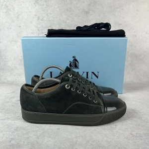 LANVIN DBB1 CAP TOE SNEAKER - – Condition: 8,5/10  - Size: 40/UK6  – What is included: Dustbag  – Retail price: 5000 + SEK  Please note that Lanvins fit big and our recommendation is to go one size down