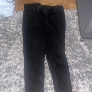 Svarta slim fit jeans från H&M - Svarta slim fit jeans från H&M med klassisk femficksdesign och dragkedjegylf. Snygg passform som sitter tajt men ändå bekvämt längs benen. Perfekta för dig som gillar en stilren och enkel look.