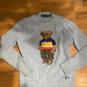 Ljusblå Polo Bear stickad tröja XS - Ljusblå stickad tröja från Polo Ralph Lauren med ikoniska Polo Bear broderad framtill. Tröjan har rund hals, ribbade muddar och RL-broderi vid nederkanten. Tillverkad i bomull och har lång ärm. Perfekt för dig som vill ha en klassisk men lekfull look. Använd ca 2 gånger inga defekter alls allt är i nytt skick ❤️