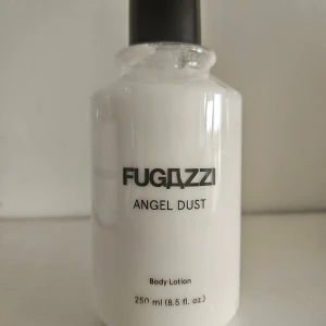 Fugazzi Angel Dust Body Lotion - Fugazzi Angel Dust Body Lotion. Innehåller sheasmör, aloe vera och Pro Vitamin B5. Doftnoter av transparent trä, cashmere och vit amber. 100% vegansk och 94% naturliga ingredienser. Volym: 250 ml.