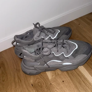Grå adidas sneakers storlek 40 - Säljer ett par grå adidas sneakers med chunky sula och coola vågiga detaljer i vitt. Ovandelen är i mesh och syntet för en sportig vibe. Skorna har snörning och en robust, mönstrad sula för extra komfort. Perfekta för dig som gillar streetstyle.
