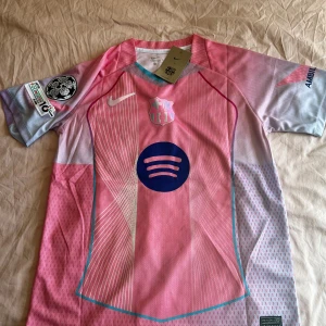 FC Barcelona Lamine Yamal rosa matchtröja - Säljer en FC Barcelona matchtröja. Hög kvalité och snygg design – perfekt för dig som vill ha Barca-looken utan att lägga för mycket pengar. Skön passform Lamine Yamal #10 på ryggen Exklusiv design i rosa/lila nyanser med Spotify-logga Funkar lika bra på träning som till vardags för alla som älskar Barcelona-stilen. 📩 Hör av dig vid frågor! Snabb leverans.