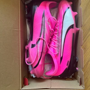 Puma Ultra Ultimate FG/AG Rosa - Säljer ett par Puma fotbollsskor som är använda endast en träning! Säljer dem för att jag slutade på fotboll tätt inpå att jag köpt dem. Skick 9/10, tecken på användning. Nypris: 2600kr.  Hör av er vid frågor och pris kan diskuteras!
