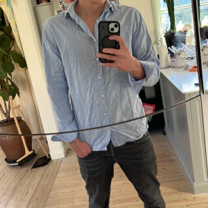 Blå slim fit skjorta från The Shirt Factory - Snygg ljusblå skjorta från The Shirt Factory i slim fit-modell. 